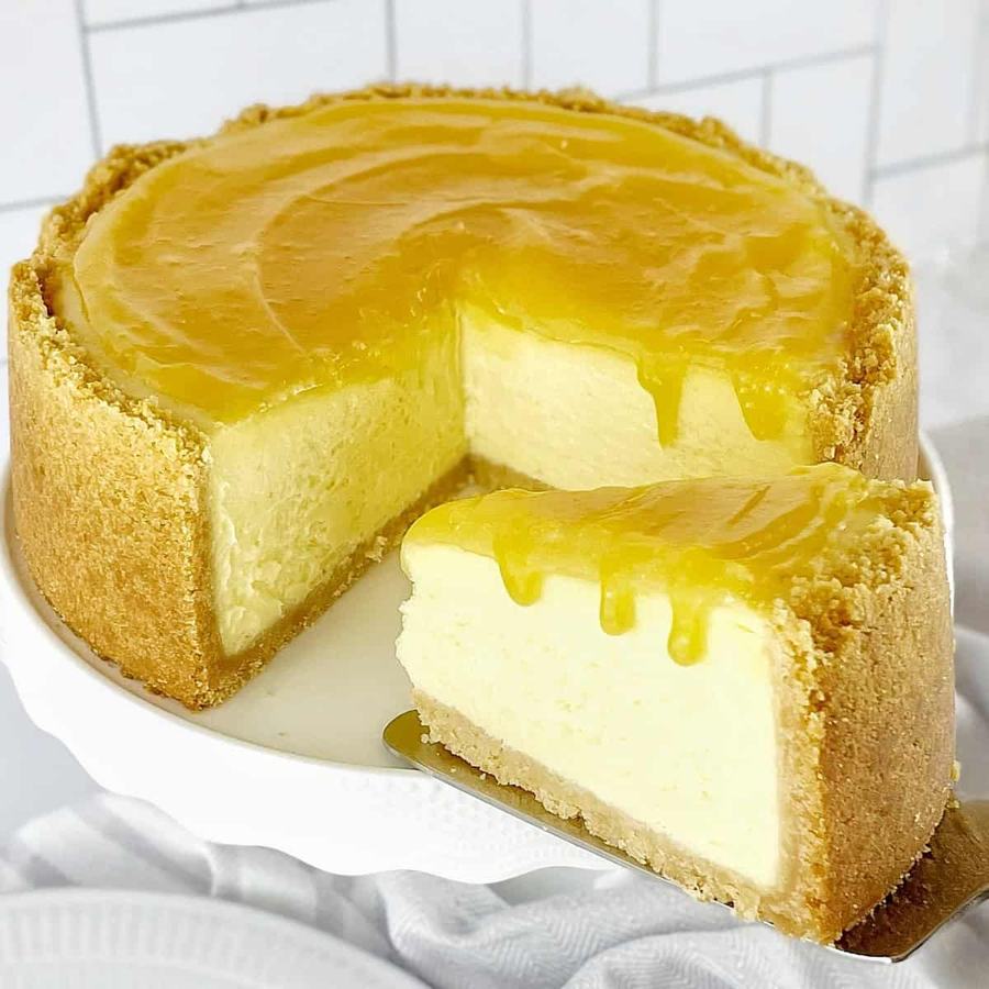 No‑bake lemon curd cheesecake on a cookie base, garnished with lemon zest curls