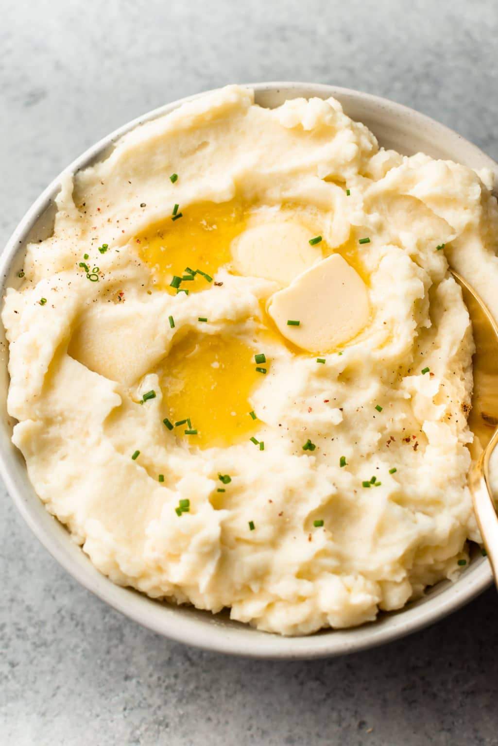 Slow cooker filled with rich creamy mashed potatoes topped with garlic butter and parsley