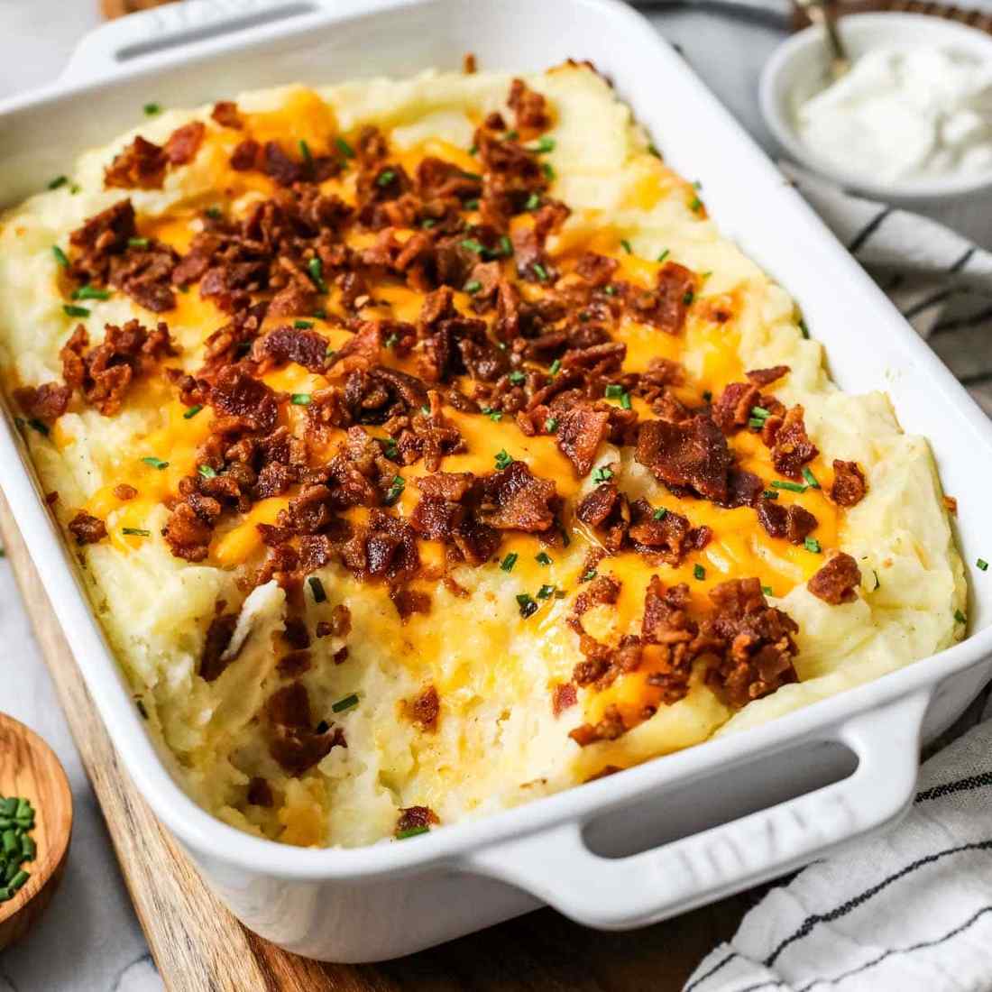 Loaded mashed potato casserole bubbling with sharp cheddar cheese, crispy bacon, and green onions