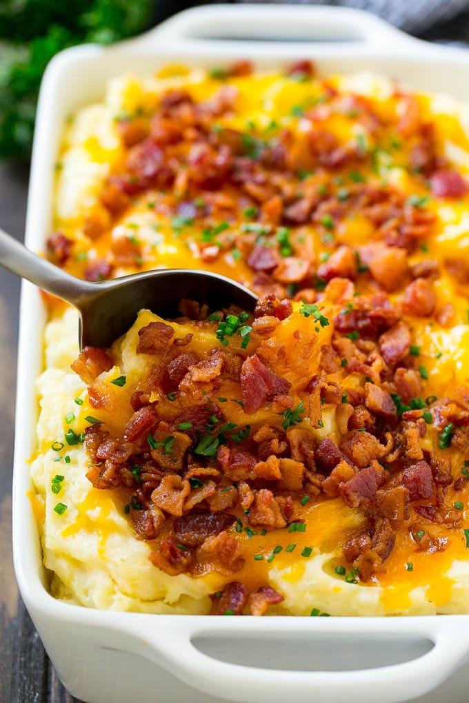 Gourmet mashed potato casserole topped with melted smoked Gouda cheese, crispy prosciutto, and fresh thyme