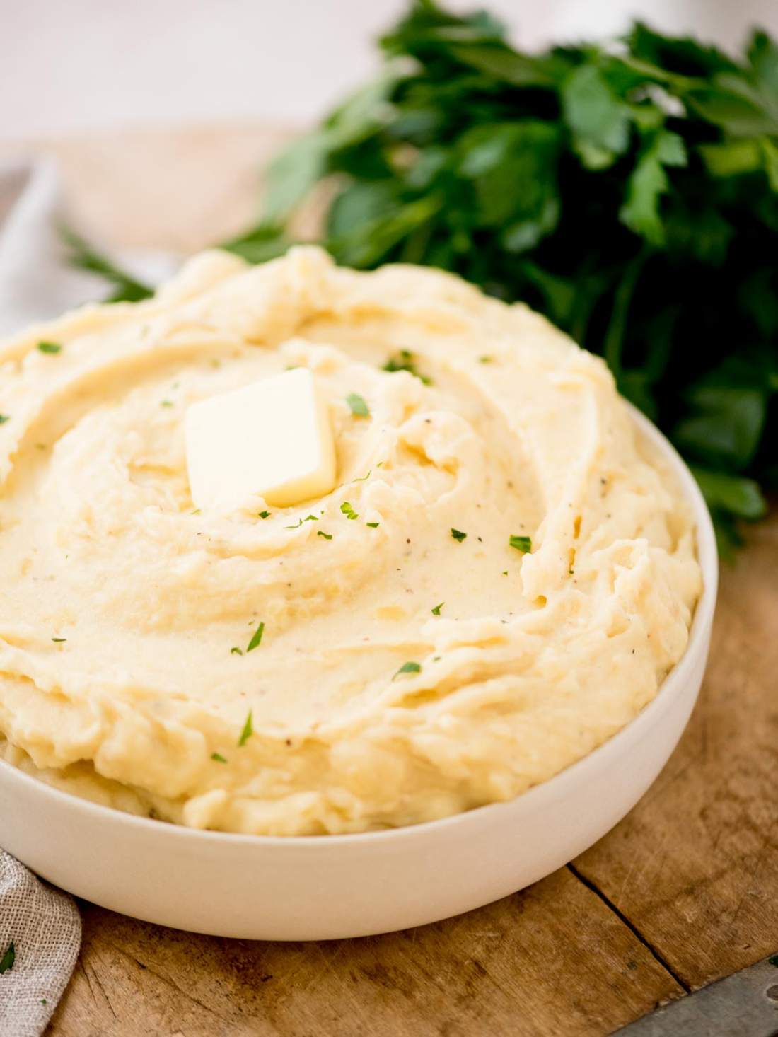 Creamy slow cooker mashed potatoes whipped with rich butter and roasted garlic in warm bowl