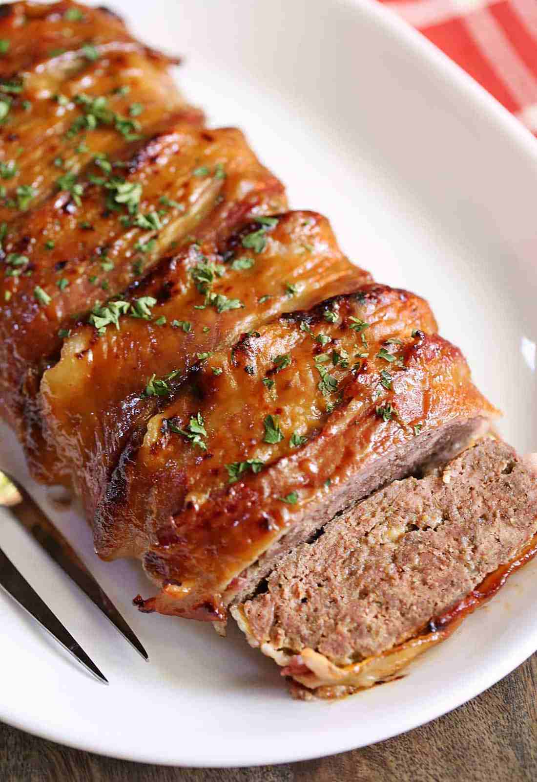 Smoky bacon-wrapped meatloaf with glossy tomato glaze, golden crust, and juicy interior