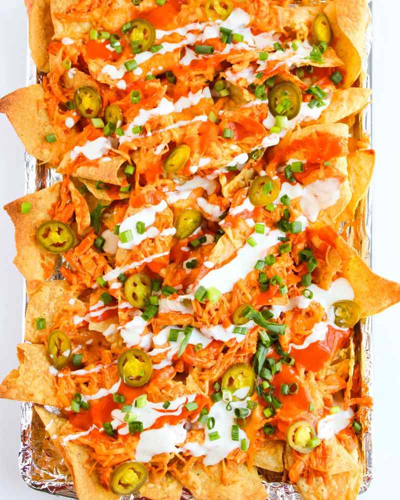 Spicy buffalo chicken nachos layered with melted cheese, blue cheese crumbles, jalapeños, and loaded tortilla chips