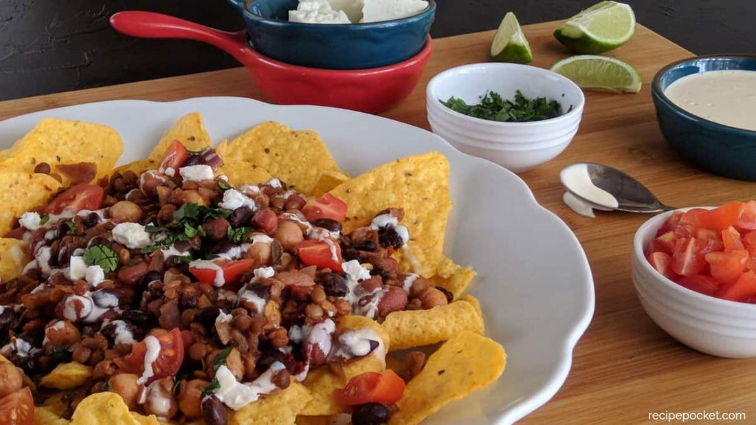 Roasted veggie nachos with cotija cheese, creamy guacamole, melted oaxaca cheese, jalapeños, and tortilla chips