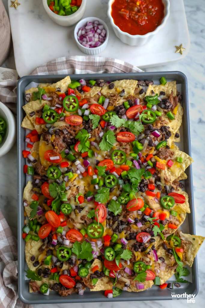 Classic loaded nachos with melted cheese, spicy jalapeños, guacamole, sour cream, and loaded tortilla chips