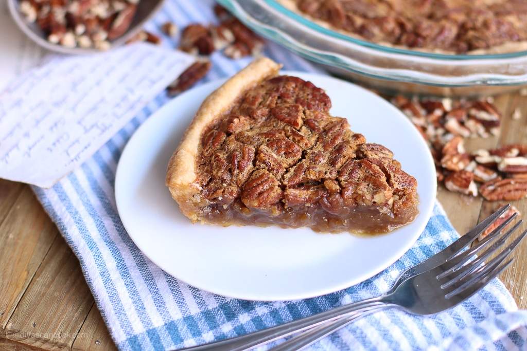 Slice of brown butter golden classic pecan pie showing rich gooey caramel filling