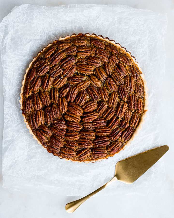Spiced maple pecan pie slice with flaky golden crust and toasted pecan caramel filling