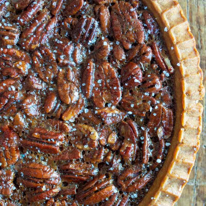 Brown sugar salted caramel pecan pie slice with toasted pecans and golden filling on plate