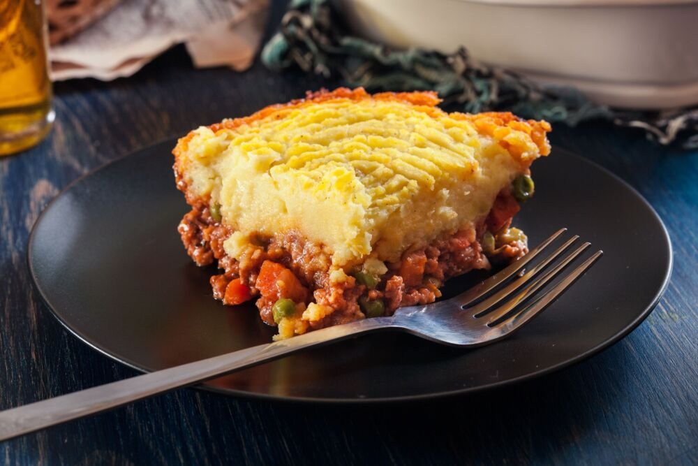 Golden mashed potato topped homestyle shepherd's pie with savory beef filling, bubbling cheese
