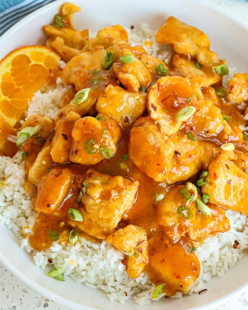 Chicken glazed in orange sauce, topped with fresh basil leaves and a drizzle of sesame oil