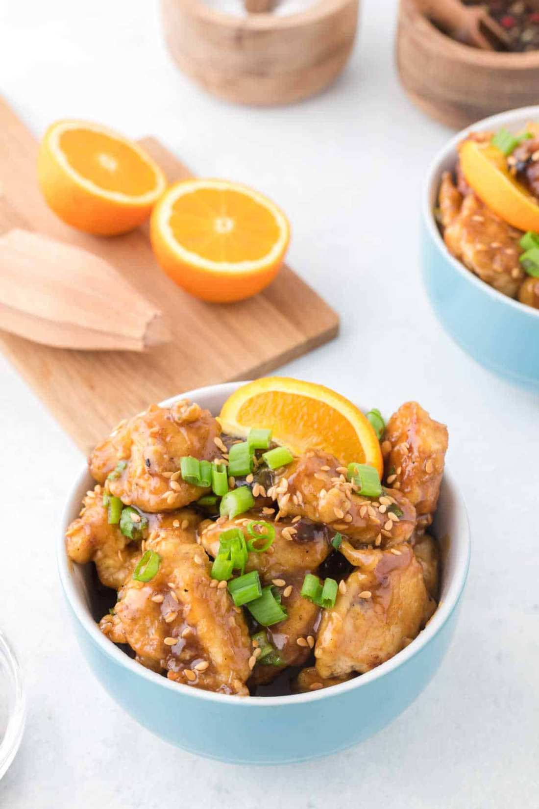 Chicken coated in a sesame‑ginger crust, glazed with orange sauce, topped with fresh orange slices