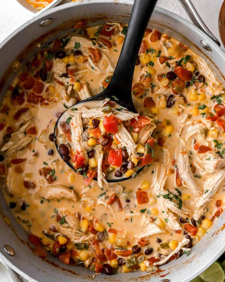 Creamy avocado lime chicken tortilla soup with smooth broth, shredded chicken, crispy tortilla strips, avocado, and lime