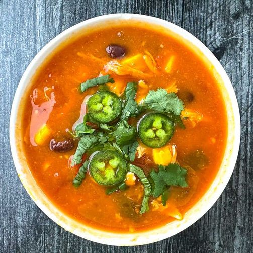 Chicken tortilla soup, ancho‑chili tomato broth, shredded chicken, crisp tortilla strips, avocado, lime