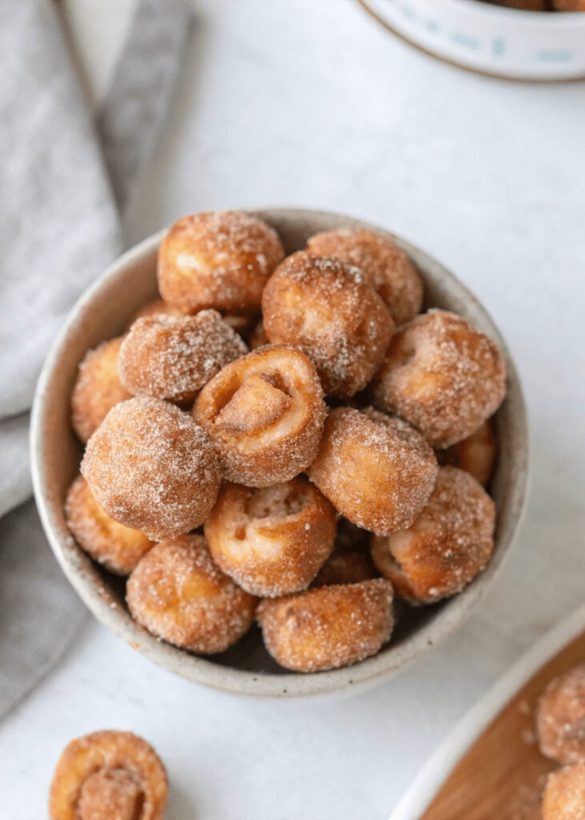 Crispy golden pretzel bites coated in cinnamon sugar, paired with caramel dip, glossy and inviting