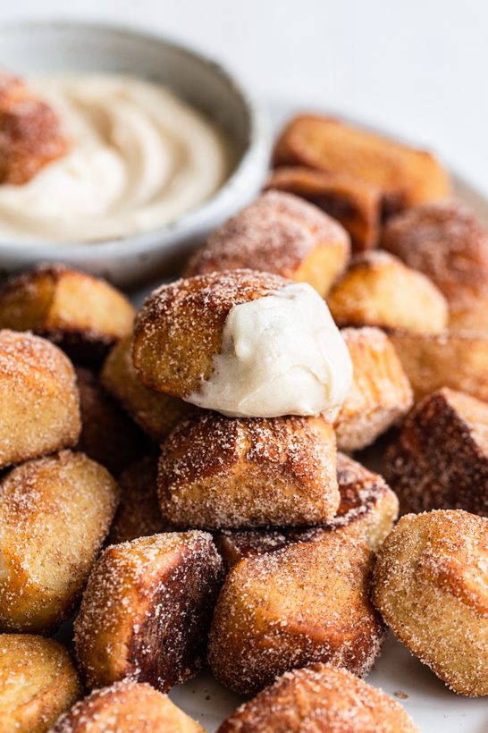 Soft pretzel bites dusted in cinnamon sugar, served with a creamy vanilla dip, golden and inviting
