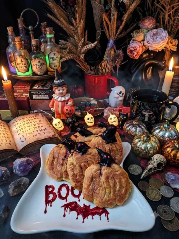 Pumpkin scones topped with dark chocolate raven cutouts on a plate