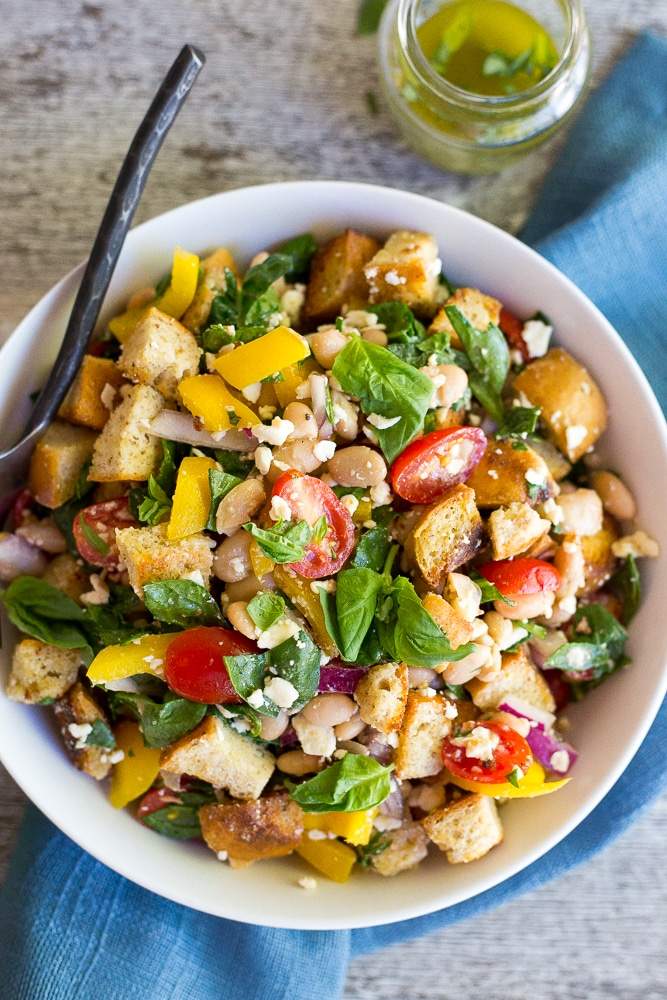 Classic summer panzanella salad featuring crusty bread cubes, ripe tomatoes, basil, mozzarella, olive oil