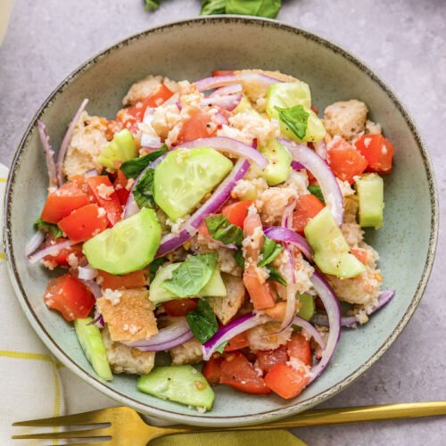 Classic summer panzanella with toasted bread cubes, juicy tomatoes, basil, mozzarella, and a zesty vinaigrette
