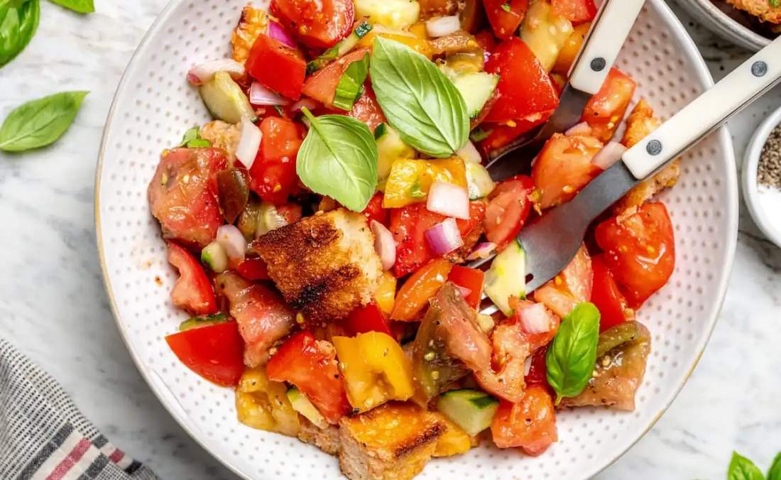 Classic summer panzanella with toasted bread cubes, ripe tomatoes, basil, mozzarella, and a zesty vinaigrette