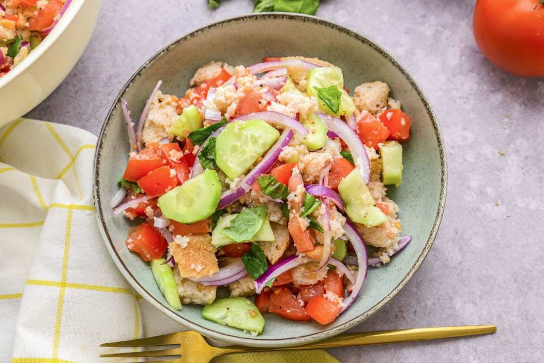 Classic summer panzanella with crusty bread cubes, ripe tomatoes, basil, mozzarella, and a bright vinaigrette