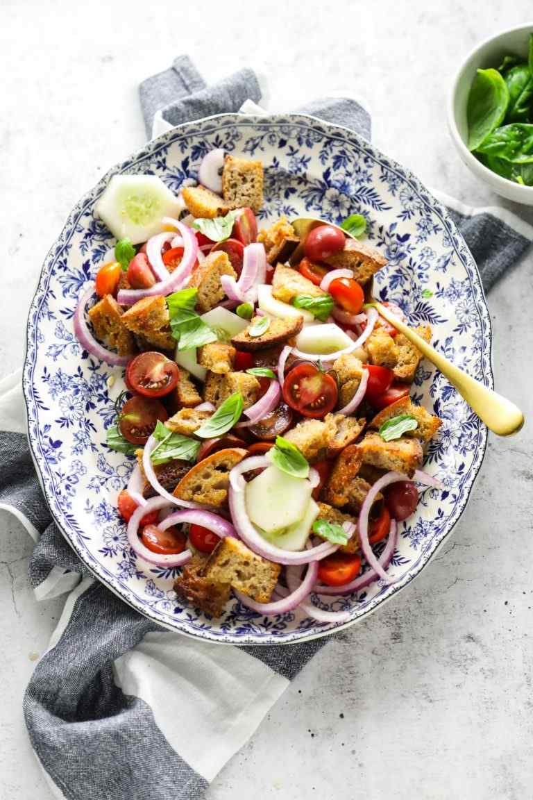 Cucumber tomato panzanella featuring crisp bread cubes, fresh cucumbers, ripe tomatoes, and basil