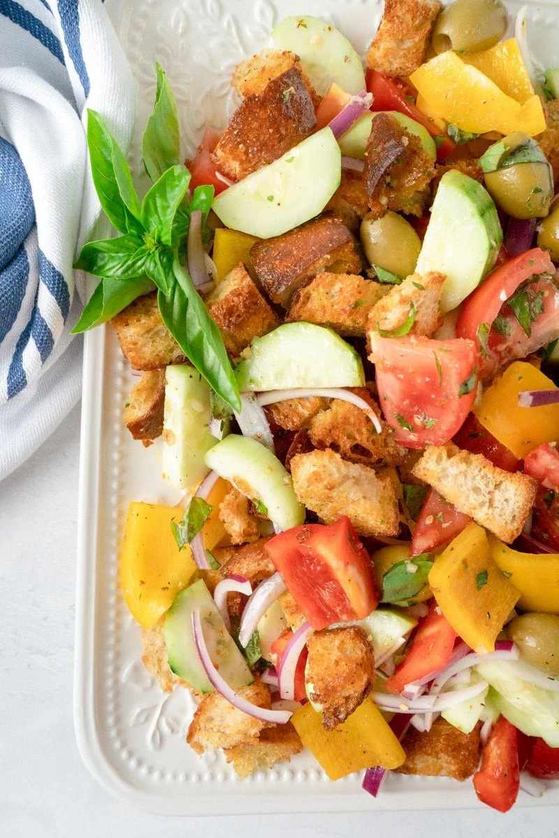 Classic summer panzanella with crusty bread cubes, ripe tomatoes, basil, mozzarella, and olive oil