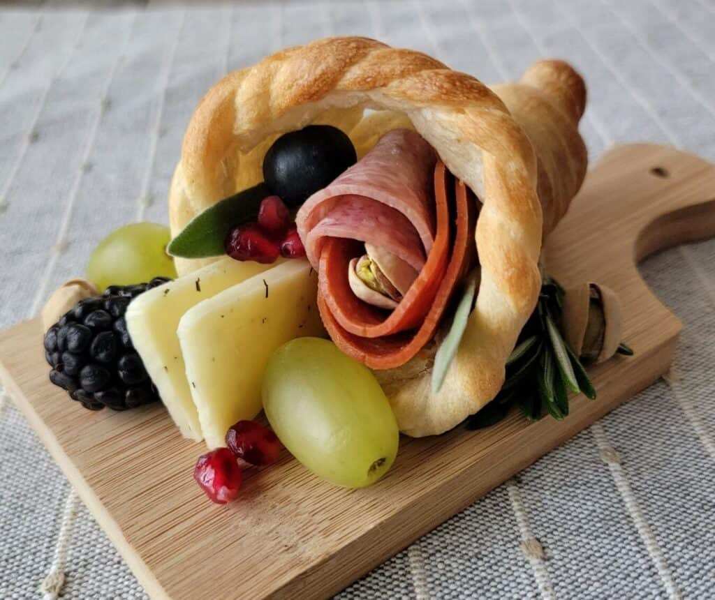 Cone‑shaped bread filled with assorted meats, cheeses, nuts, and dried fruit