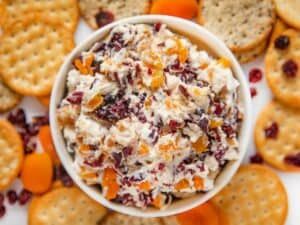 Creamy cheese dip swirled with cranberry sauce and toasted pecans, served with crackers